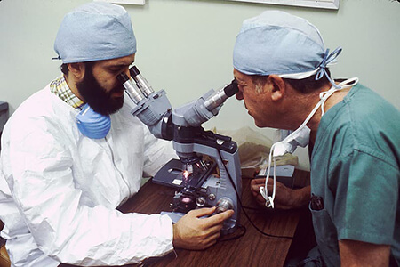 two doctors looking in microscope